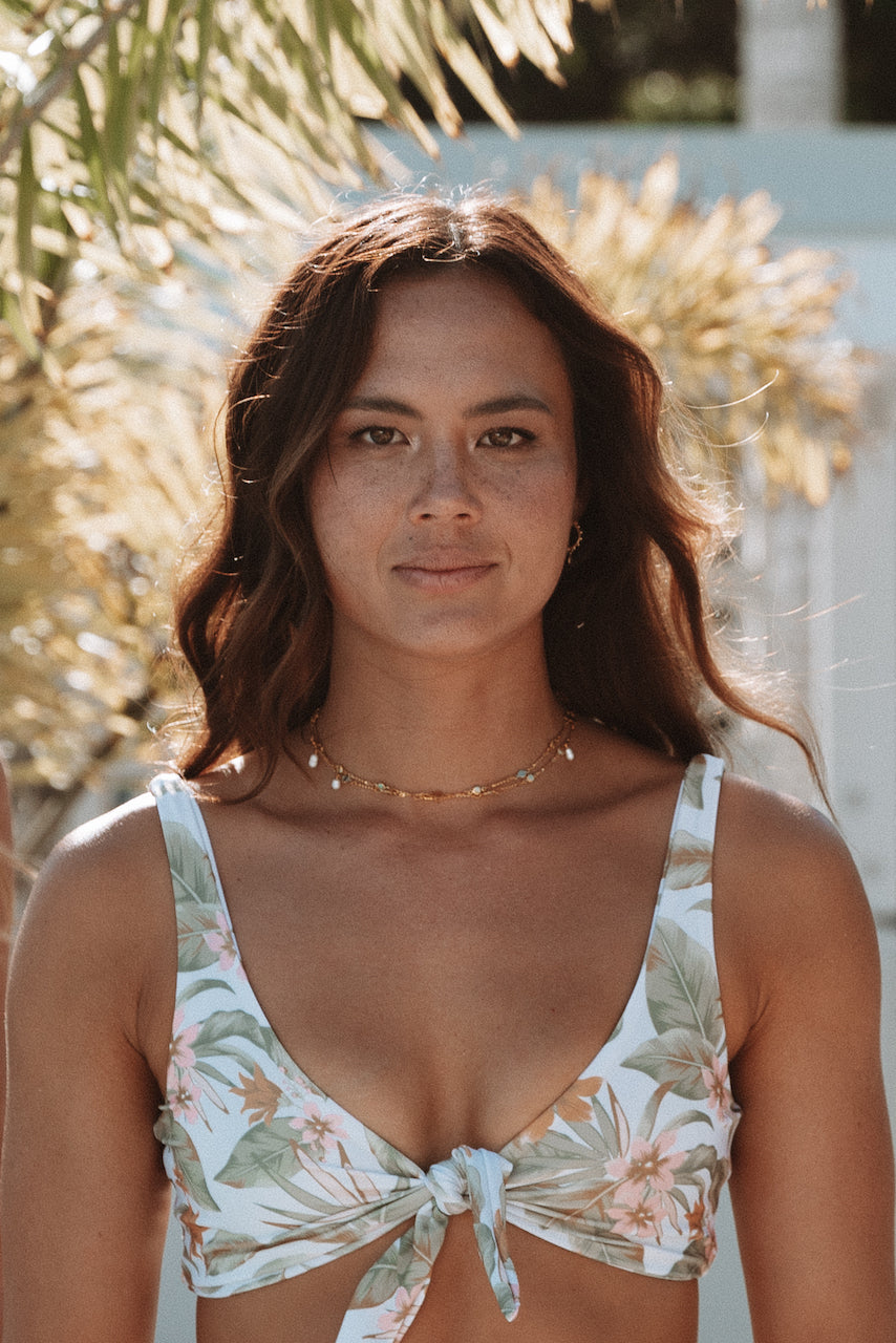 Palm Springs front tie top. This flattering and supportive top is designed for comfort in the water and out! It is an easy fit featuring adjustable straps with gold detailing and a front tie to fit a wide range of cup sizes. Soft fabric made from recycled post consumer materials. Looks cute paired with our Palm Springs Scrunchie and a range of our bottoms