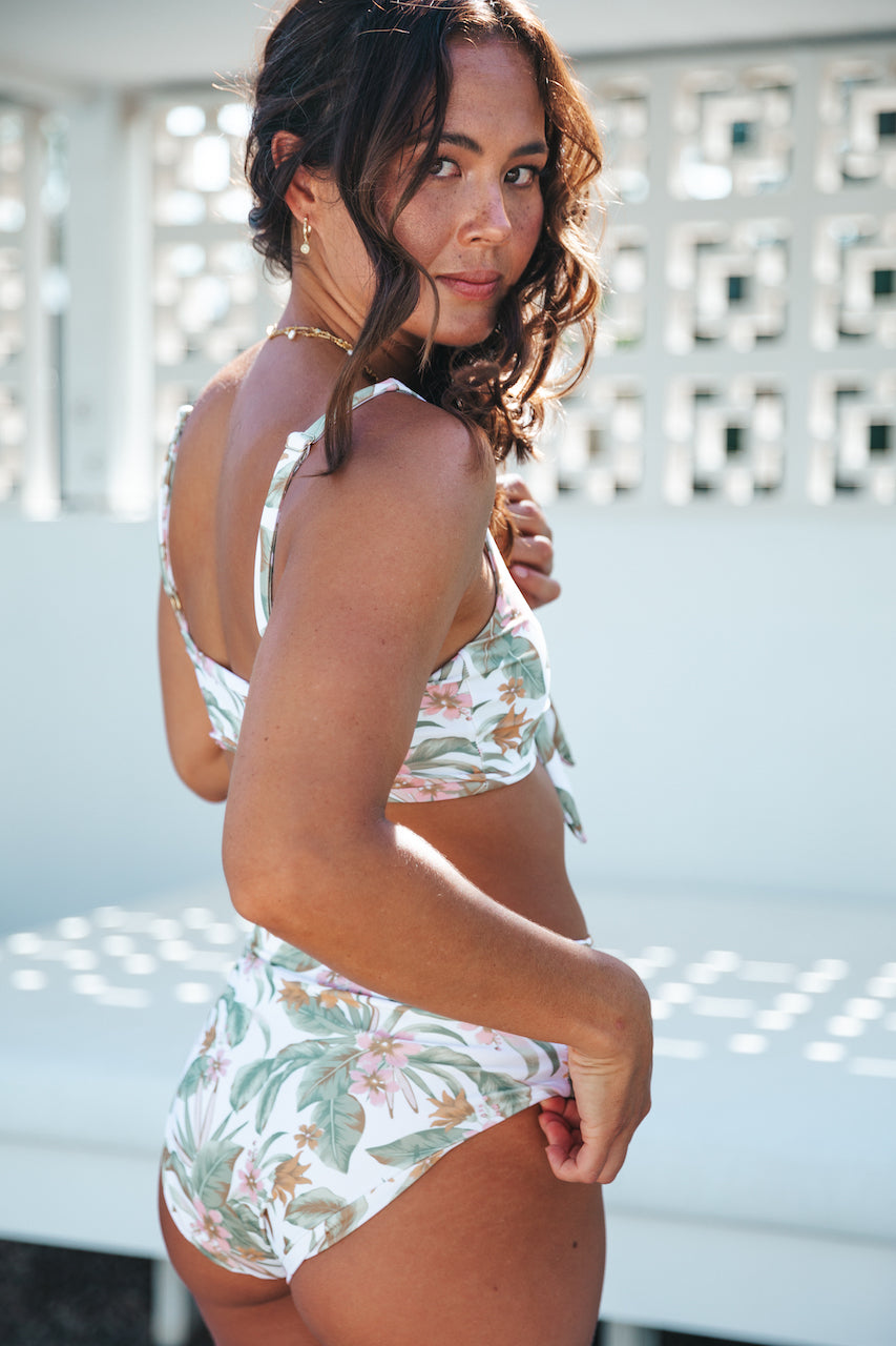 Palm Springs front tie top. This flattering and supportive top is designed for comfort in the water and out! It is an easy fit featuring adjustable straps with gold detailing and a front tie to fit a wide range of cup sizes. Soft fabric made from recycled post consumer materials. Looks cute paired with our Palm Springs Scrunchie and a range of our bottoms